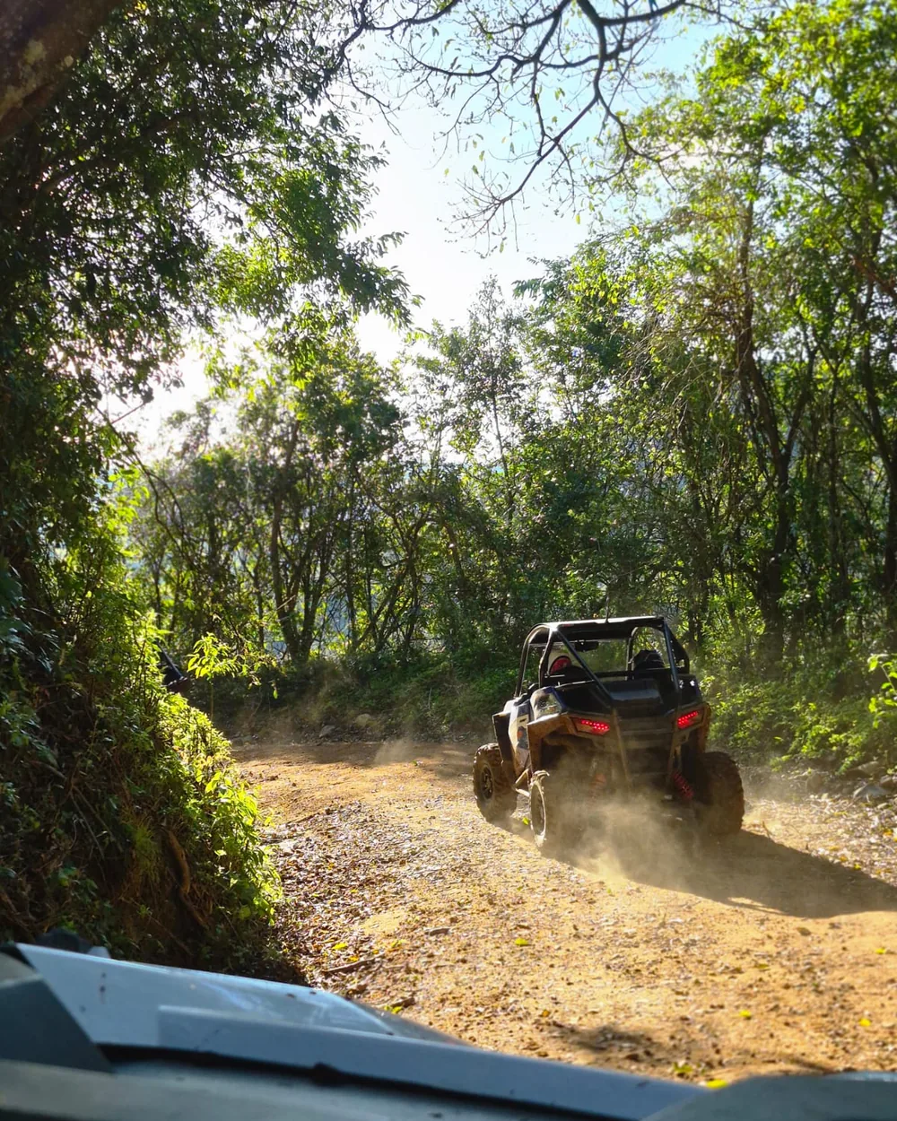 Polaris RZR levantando poeira numa estrada de chão batido